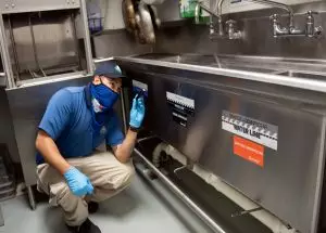 Nozzle Nolen employee checks commercial kitchen for signs of a commercial pest infestation