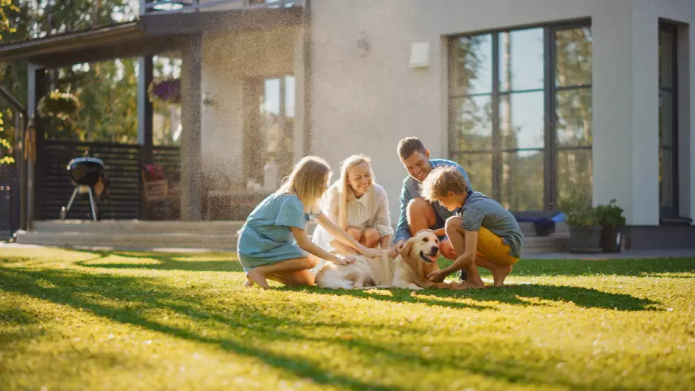 A happy family on a healthy lawn who followed the best lawn care schedule